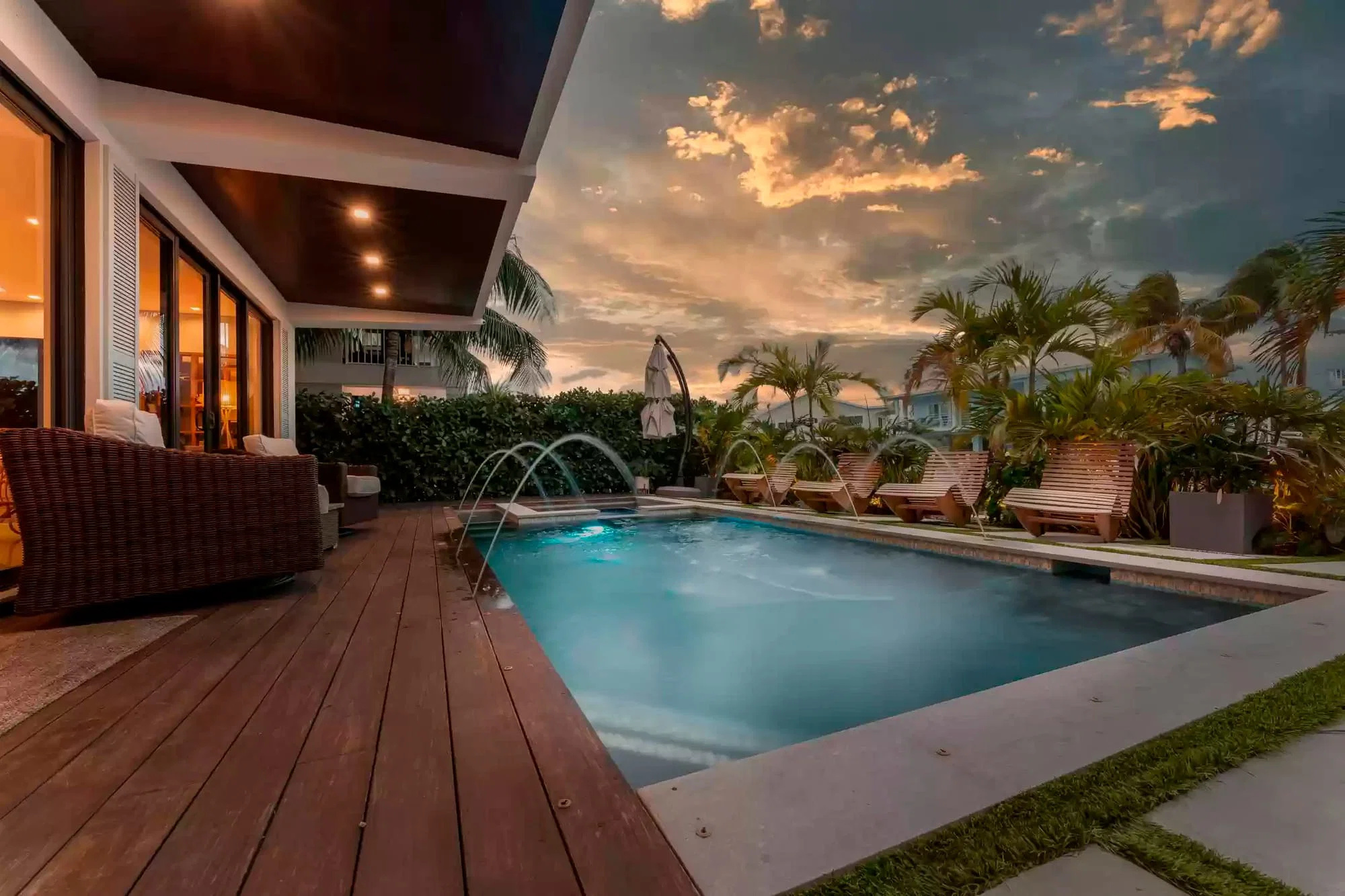 Deck de madeira nobre em borda de piscina com cascata